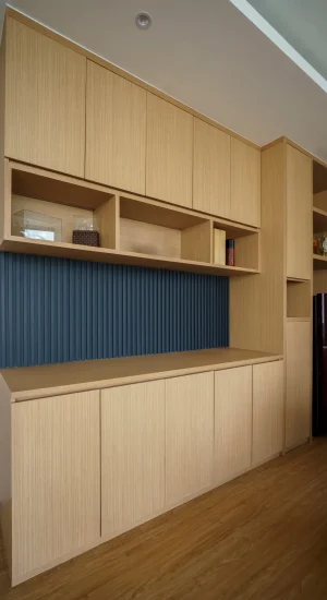 Custom built-in wooden cabinets and shelving in a modern office, featuring a dark blue fluted backsplash. Functional and stylish storage. Custom built-in wooden cabinets and shelving in a modern office, featuring a dark blue fluted backsplash. Functional and stylish storage.